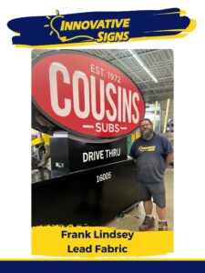 Frank Lindsey stands to the right of a large Cousins Subs monument sign.