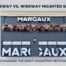 Image of a raceway mounted sign for a restaurant, Margaux, surrounded by false flowers.