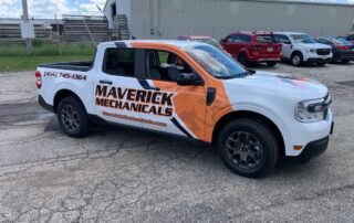 An image of a white truck wrapped in an orange and black vehicle wrap, highlighting a business' brand.