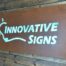 A rusted aluminum sign that says "Innovative Signs"