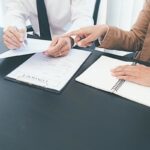 Two people discussing a contract.